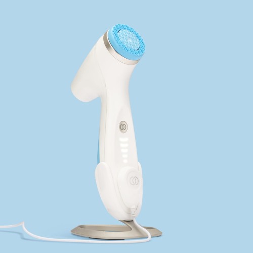 Nu Skin ageLOC LumiSpa iO - urządzenie umieszczone na magnetycznej ładowarce, zielona dioda sygnalizująca ładowanie
