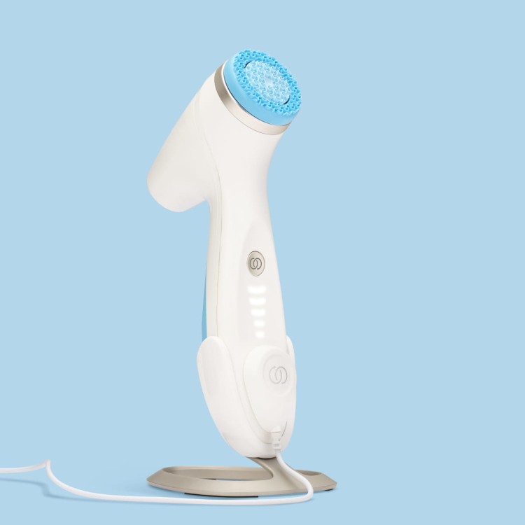 Nu Skin ageLOC LumiSpa iO - urządzenie umieszczone na magnetycznej ładowarce, zielona dioda sygnalizująca ładowanie
